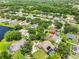 Aerial view of a home with a pool, surrounded by lush greenery and neighboring houses in a suburban setting at 12305 Freesia Ct, Riverview, FL 33569