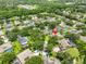 Aerial view of a property in a lush, green neighborhood, surrounded by trees and other homes at 12305 Freesia Ct, Riverview, FL 33569