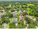 Expansive aerial view of a single-Gathering home with a screened-in pool and well-manicured lawn in a lush, green neighborhood at 12305 Freesia Ct, Riverview, FL 33569