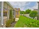 Landscaped backyard featuring a screened-in lanai, lush green grass, and mature shrubbery at 12305 Freesia Ct, Riverview, FL 33569