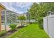 Backyard showcasing lush green grass, mature landscaping, and a screened-in pool area at 12305 Freesia Ct, Riverview, FL 33569