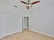 A bedroom features light wood-look floors, a ceiling fan, and a closet for storage at 12305 Freesia Ct, Riverview, FL 33569