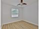 Bright bedroom with light-colored walls, wood-look floors, ceiling fan, and a window offering natural light at 12305 Freesia Ct, Riverview, FL 33569