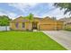 Charming home boasts lush lawn, mature trees, and a spacious three car garage at 12305 Freesia Ct, Riverview, FL 33569