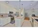 Bright kitchen showcasing an island with pendant lighting, stainless steel appliances and tile floors at 12305 Freesia Ct, Riverview, FL 33569