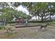Community playground with slides, climbing structures, and benches surrounded by mature trees at 12305 Freesia Ct, Riverview, FL 33569