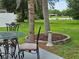 Relaxing backyard with a view of the lake, a patio set and lush green grass at 2152 Mckinley St, Clearwater, FL 33765