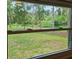 View of the large backyard through a double hung window at 2152 Mckinley St, Clearwater, FL 33765