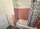 Hall bathroom featuring a shower and tub combination with pink ceramic tile at 2152 Mckinley St, Clearwater, FL 33765