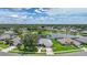 Lovely aerial view of homes, lake, trees, manicured lawns and clear blue skies at 2226 Charleston Park Dr, North Port, FL 34287