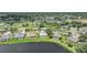 Expansive aerial showing neighborhood with lake, screened pools, and green landscape at 2226 Charleston Park Dr, North Port, FL 34287