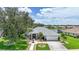 Beautiful single-story home with lush landscaping, large trees, and a well-manicured lawn near a scenic pond at 2226 Charleston Park Dr, North Port, FL 34287