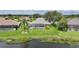 Backyard with a pool, screened enclosure, lush lawn, and a scenic pond view, perfect for outdoor living at 2226 Charleston Park Dr, North Port, FL 34287