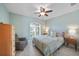Serene bedroom with a cozy armchair, neutral walls, ceiling fan, and a window for natural light at 2226 Charleston Park Dr, North Port, FL 34287