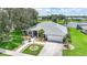 Beautiful single-story home with lush landscaping, large trees, and a well-manicured lawn near a scenic pond at 2226 Charleston Park Dr, North Port, FL 34287