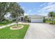 Charming single-story home featuring a well-manicured lawn, mature trees, and a two-car garage at 2226 Charleston Park Dr, North Port, FL 34287