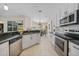 Well-lit kitchen featuring white cabinets, stainless steel appliances, and a view into the dining area at 2226 Charleston Park Dr, North Port, FL 34287