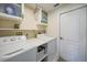 Functional laundry room equipped with washer, dryer, storage shelves, and a folding area at 2226 Charleston Park Dr, North Port, FL 34287