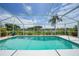 Stunning screened pool with clear blue water, surrounded by lush landscaping and a tranquil lake view at 2226 Charleston Park Dr, North Port, FL 34287