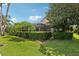Lush backyard featuring a screened-in lanai, privacy hedges, mature trees and manicured landscaping at 23346 Abercorn Ln, Land O Lakes, FL 34639