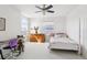 This bedroom features a ceiling fan, a desk, and a white bed at 23346 Abercorn Ln, Land O Lakes, FL 34639