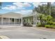 Exterior of clubhouse showing entryway with a covered portico, shade trees, and plants at 23346 Abercorn Ln, Land O Lakes, FL 34639