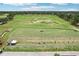 Aerial view of driving range with a manicured lawn, greenway, and a group of people practicing at 23346 Abercorn Ln, Land O Lakes, FL 34639