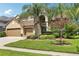 Charming home with a lush green lawn, mature landscaping, and a beautiful crape myrtle tree at 23346 Abercorn Ln, Land O Lakes, FL 34639