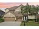 Charming two-story home with a three-car garage, lush landscaping, and a beautiful lawn at 23346 Abercorn Ln, Land O Lakes, FL 34639