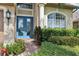 Inviting entryway with a bright blue front door, brick walkway, and manicured landscaping at 23346 Abercorn Ln, Land O Lakes, FL 34639