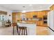 Spacious kitchen features an island with granite countertops, wood cabinets, and stainless steel appliances at 23346 Abercorn Ln, Land O Lakes, FL 34639