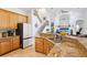 Bright kitchen with granite countertops, wood cabinets, and stainless steel appliances, adjacent to the living area at 23346 Abercorn Ln, Land O Lakes, FL 34639