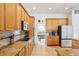 Well-equipped kitchen with granite countertops, wood cabinets, stainless steel appliances, and an eat-in area at 23346 Abercorn Ln, Land O Lakes, FL 34639