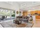 Open-concept living room with a brown sofa, high ceilings, and a view of the pool and patio at 23346 Abercorn Ln, Land O Lakes, FL 34639
