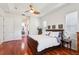 Cozy main bedroom with hardwood floors, a tray ceiling, and ensuite bathroom access at 23346 Abercorn Ln, Land O Lakes, FL 34639