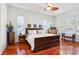 Comfortable main bedroom with hardwood floors, a tray ceiling, and plenty of natural light at 23346 Abercorn Ln, Land O Lakes, FL 34639