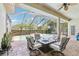 The screened in pool area includes a covered patio with furniture and tropical landscaping at 23346 Abercorn Ln, Land O Lakes, FL 34639