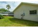 Well-maintained backyard with a lush lawn, mature trees, and a view of the screened-in patio at 2421 Eagle Chase Dr, Palm Harbor, FL 34683