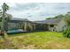 The spacious backyard features a well-maintained lawn, mature trees, and a screened-in pool area at 2421 Eagle Chase Dr, Palm Harbor, FL 34683