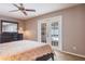 Bedroom with ceiling fan, doors to the outside and view of the pool at 2421 Eagle Chase Dr, Palm Harbor, FL 34683