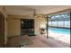 Covered outdoor patio area with sliding glass doors and a built-in grill, with pool views at 2421 Eagle Chase Dr, Palm Harbor, FL 34683