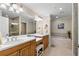 Well-lit bathroom featuring double sinks, vanity, soaking tub, and walk-in shower at 3805 Gulf Blvd # 401, St Pete Beach, FL 33706
