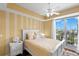 Charming bedroom with a queen bed, bright decor, and balcony overlooking a waterway at 3805 Gulf Blvd # 401, St Pete Beach, FL 33706