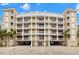 Elegant condo building featuring multi-story balconies, grand architecture, and ample parking at 3805 Gulf Blvd # 401, St Pete Beach, FL 33706