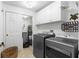 This laundry room includes a washer and dryer, plenty of storage cabinets, and tile floors at 3805 Gulf Blvd # 401, St Pete Beach, FL 33706