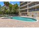 Community pool with a hot tub surrounded by brick pavers in front of the condo building at 3805 Gulf Blvd # 401, St Pete Beach, FL 33706
