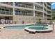 Community pool with a hot tub surrounded by brick pavers in front of the condo building at 3805 Gulf Blvd # 401, St Pete Beach, FL 33706
