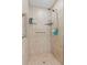 Walk-in shower with tiled walls, multiple shower heads, and glass shelving at 3805 Gulf Blvd # 401, St Pete Beach, FL 33706