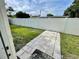 A fenced backyard has a concrete tile pathway and a well-manicured lawn at 7026 20Th N St, St Petersburg, FL 33702