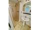 Bathroom with a pedestal sink, a shower, tile flooring, and a round mirror at 7026 20Th N St, St Petersburg, FL 33702